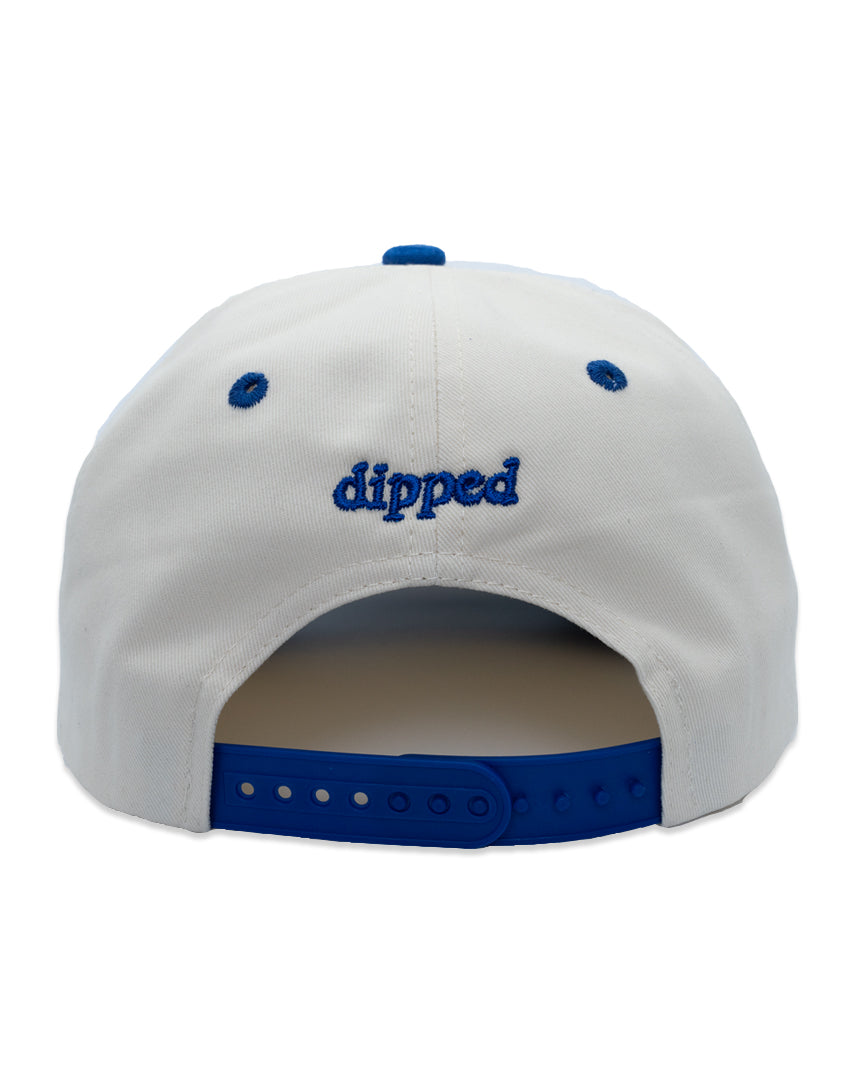 A two-tone Dodger Blue snapback cap with 'Enjoy the Trip' on the front, featuring a white crown and a blue visor.