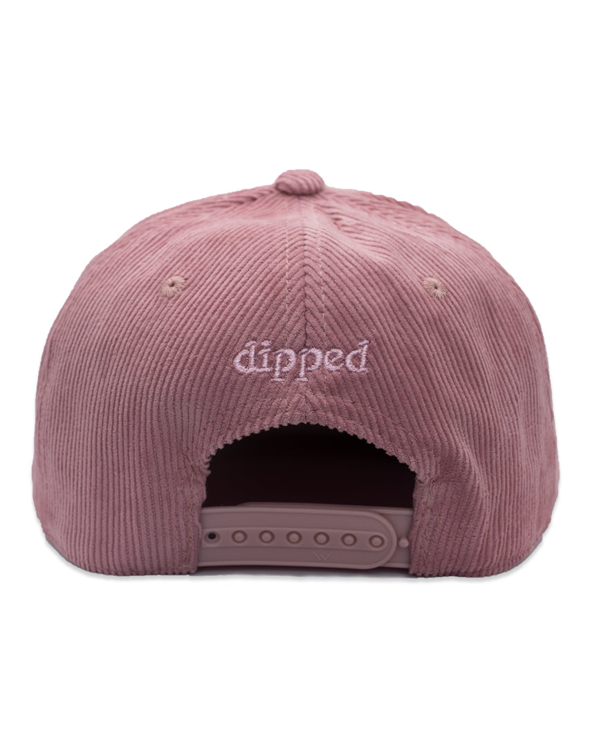 Pink corduroy cap with 'Enjoy the Trip' text on a white background