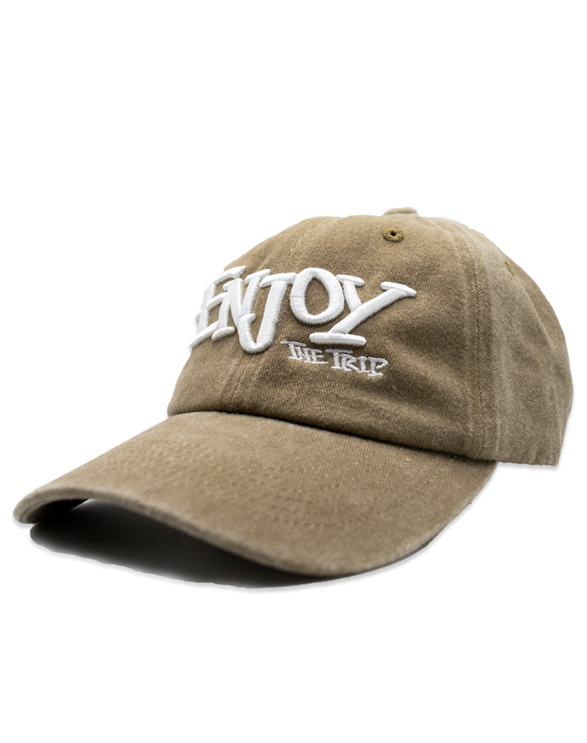 Tan Dad Hat with white embroidery 'ENJOY THE TRIP' on a white background