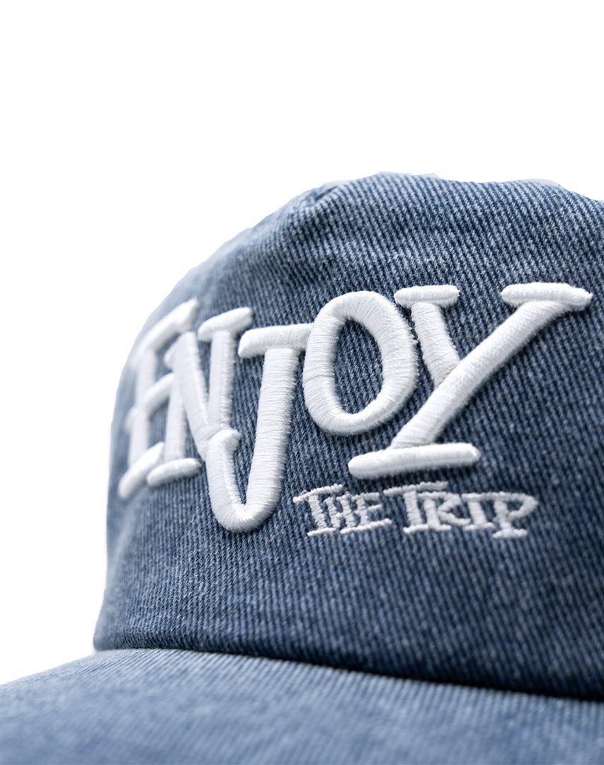 Blue Washed Denim hat with white embroidery 'ENJOY THE TRIP' on a white background