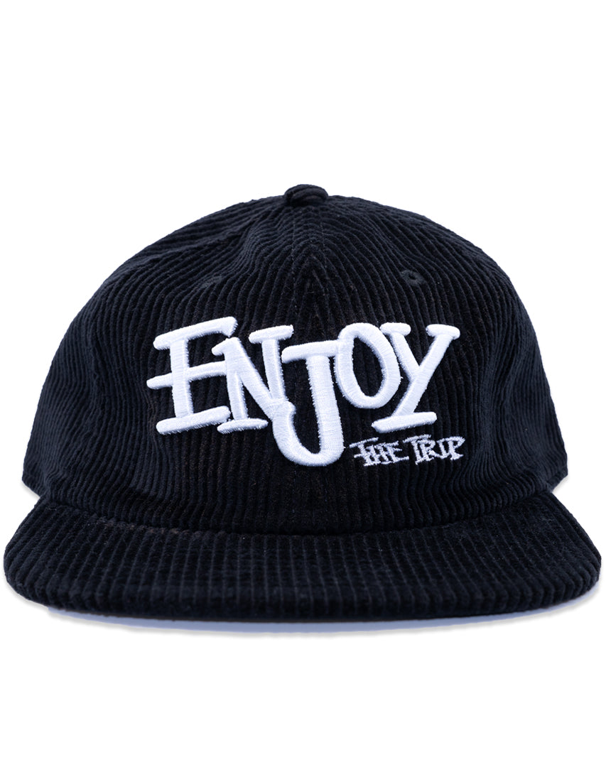 Black corduroy cap with white text 'ENJOY THE TRIP' on a white background